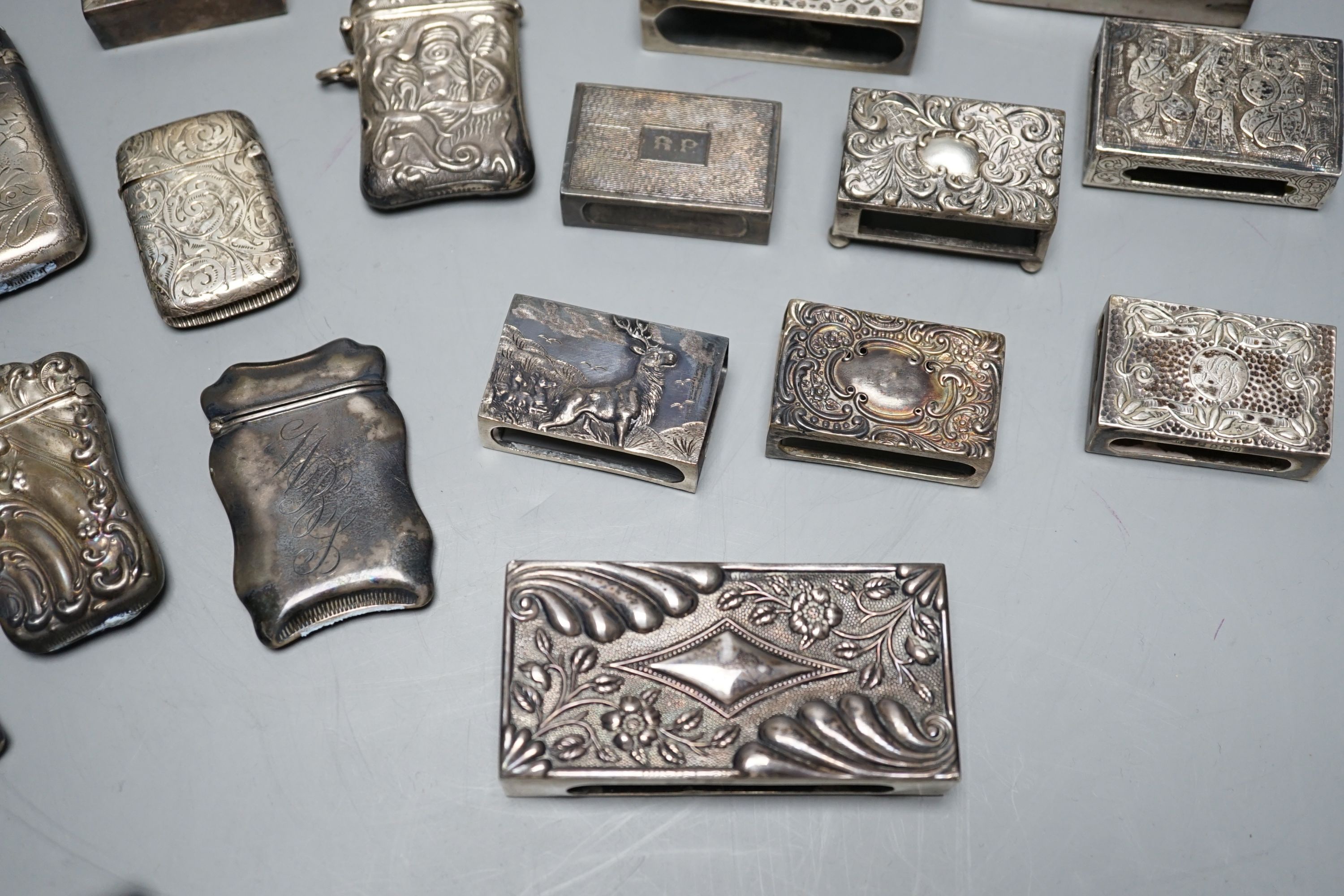 A small collection of nine mainly early 20th century silver or sterling vesta cases, largest 60mm and fourteen assorted similar silver or white metal match sleeves